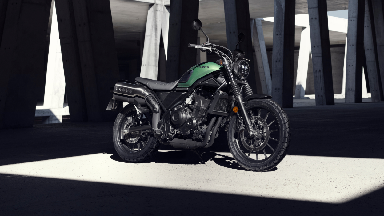 A Honda SCL500 parked under a concrete structure