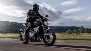 A rider on a Honda standard motorcycle on a sunny day 