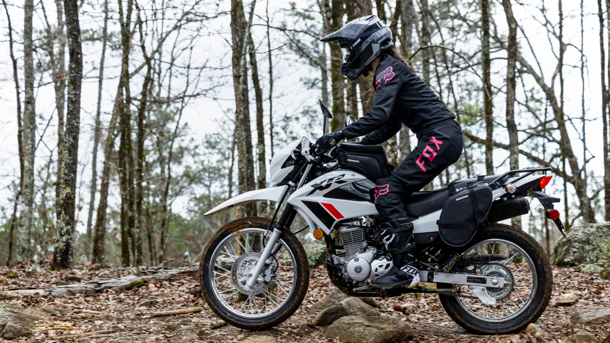 Un cavalier dans les bois sur une honda xr150l
