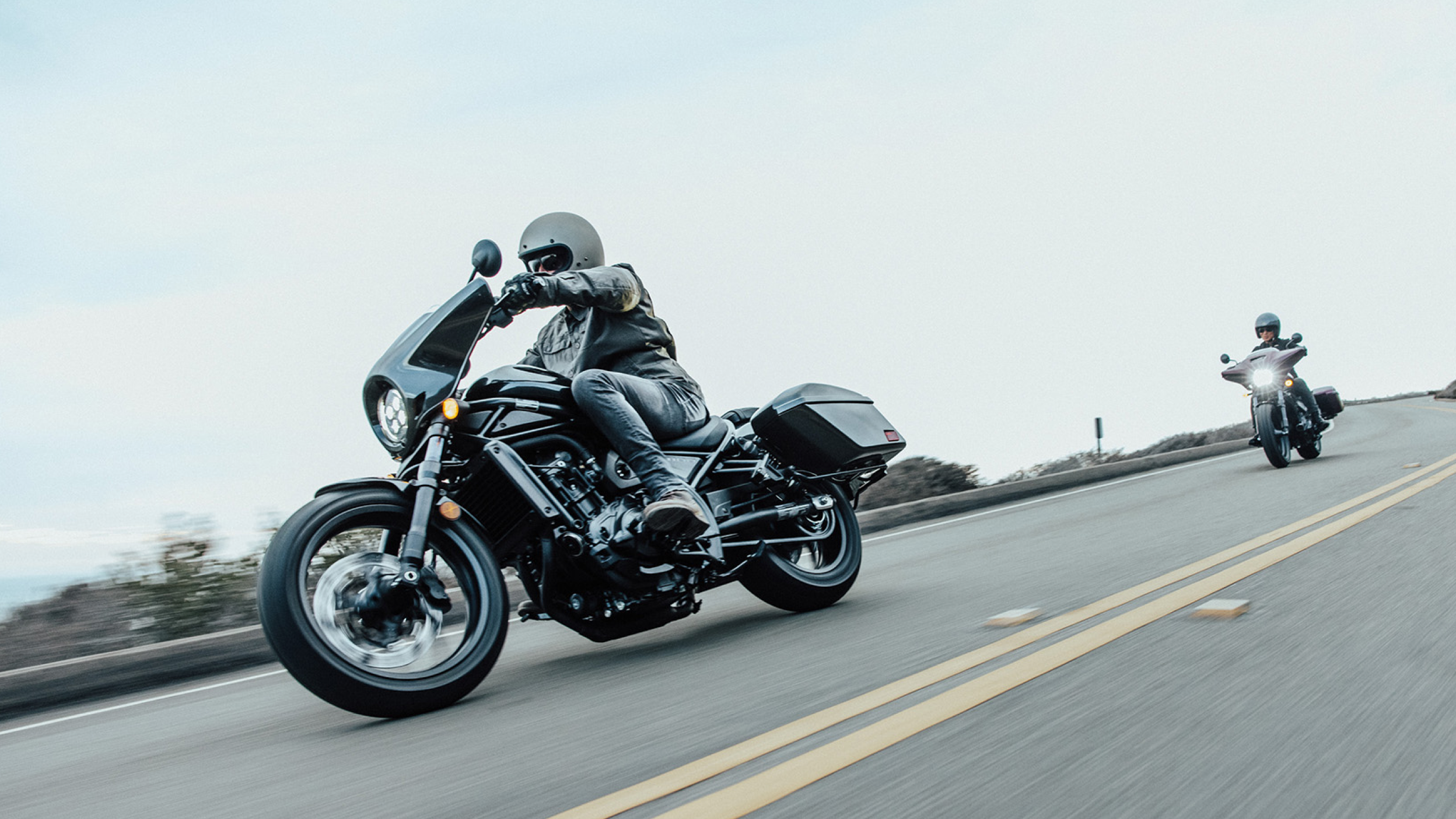 Two riders on Honda Rebels on the highway 