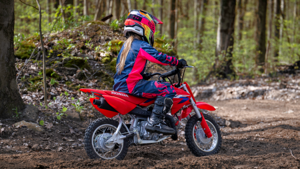 A young rider on a CRF50F on a trail