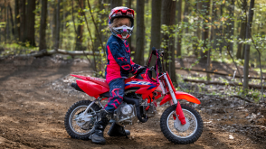 A young rider stopped on a CRF50F