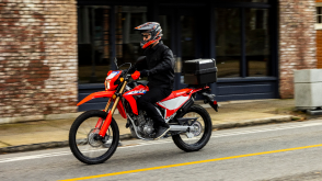 A side angle view of a person riding the Honda CRF300L on a city street
