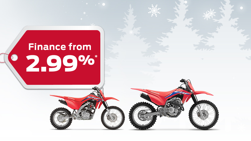 Two CRF Trail bikes on a winter background with snowflakes, with a red gift tag advertising a 2.99% interest rate