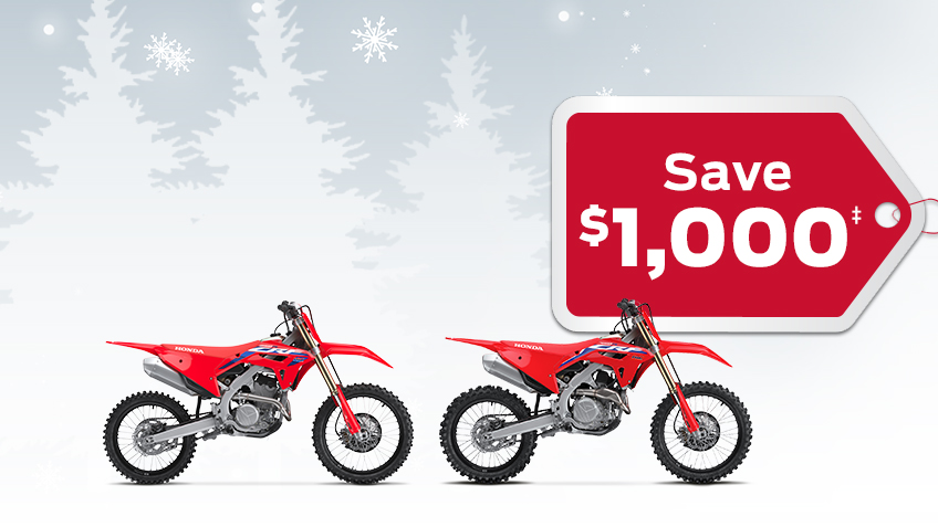 2 CRF Competition bikes on a winter background with snowflakes, with a red gift tag advertising a $1000 discount